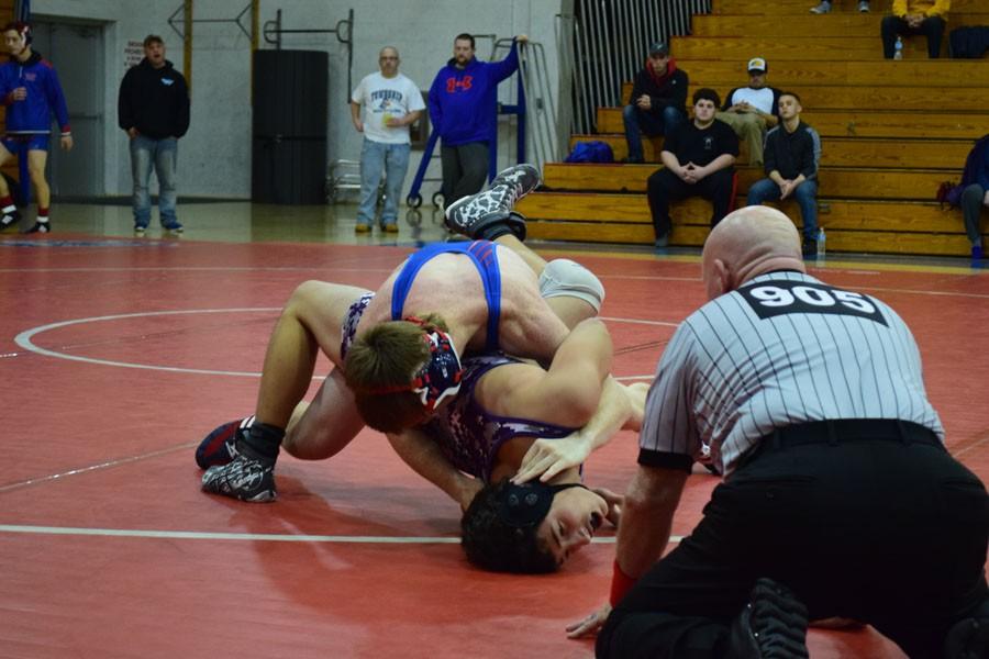 Varsity Wrestler George Stuart 17 takes on opponent during a home match. The wrestling season began in December and practices are still ongoing.