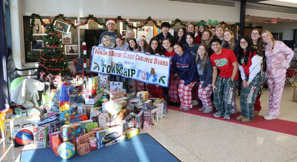 Junior and Senior class council members pose in front of toy donations collected during the 25th annual Twp Toys event.